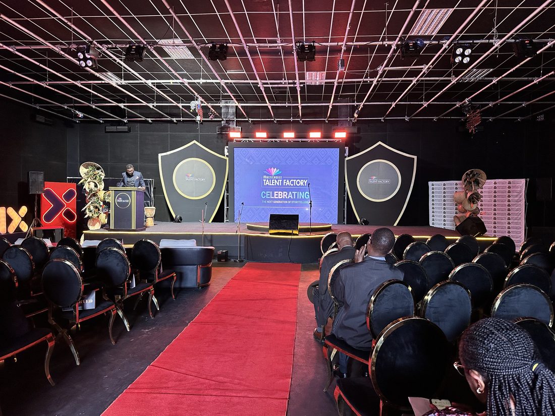An awards stage in the round with twin trophy shields and a full lighting rig