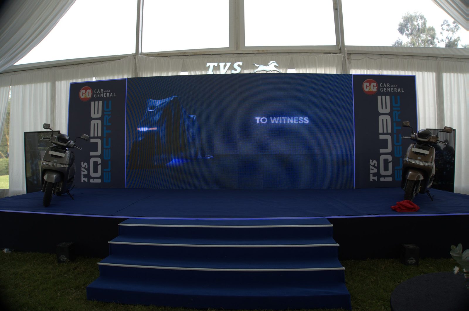 A launch stage with a blue LED wall and steps, set before the audience arrives