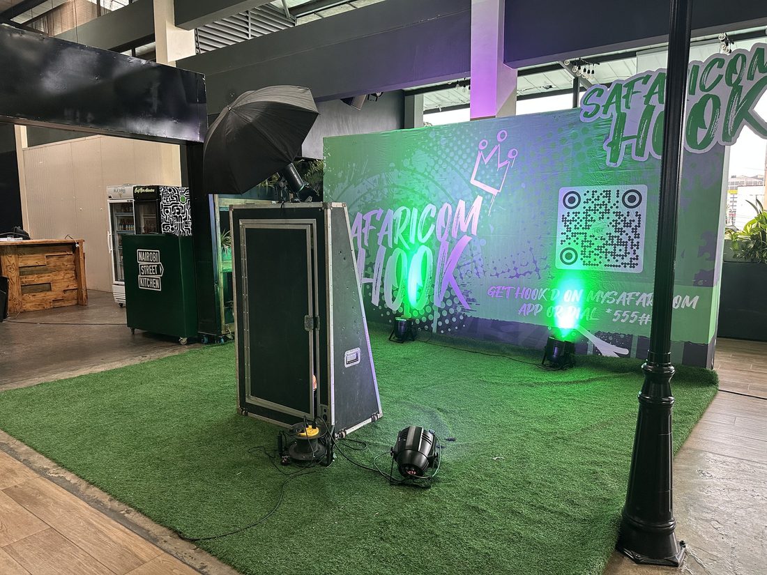 A neon-lit activation set on artificial turf photographed after dark