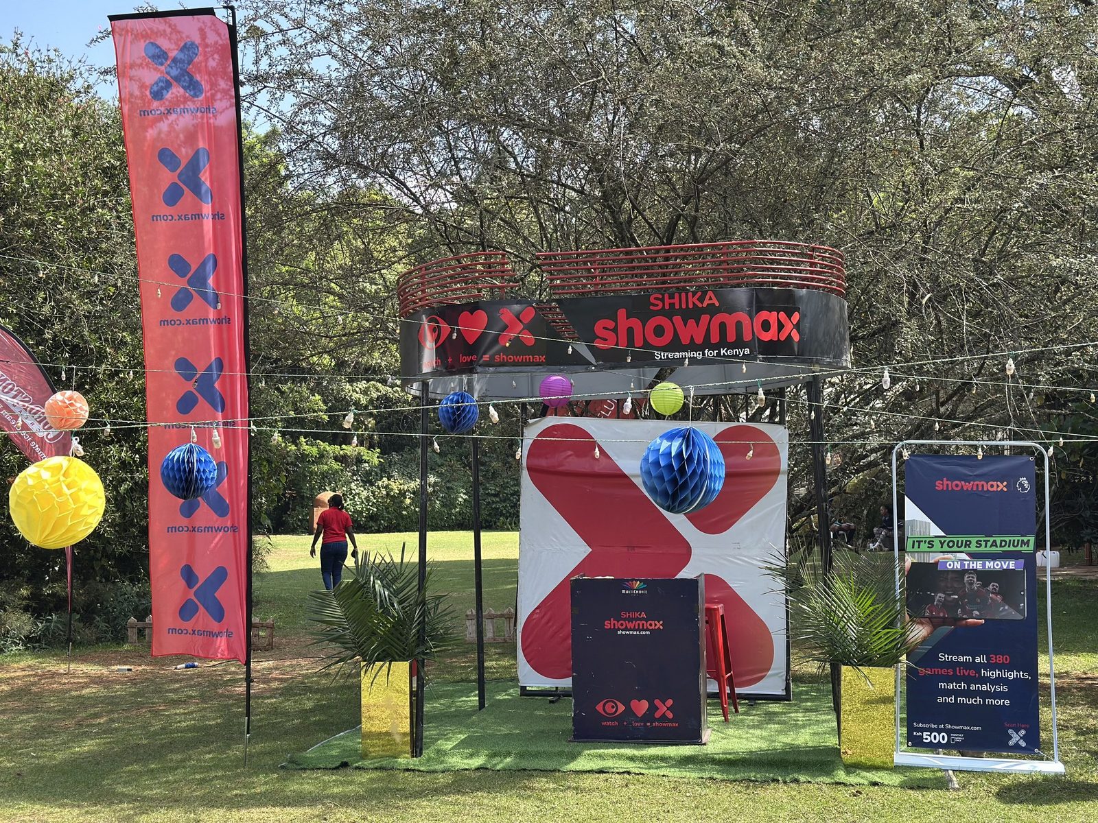 A Showmax activation on a lawn with a sculptural X and balloon dressing