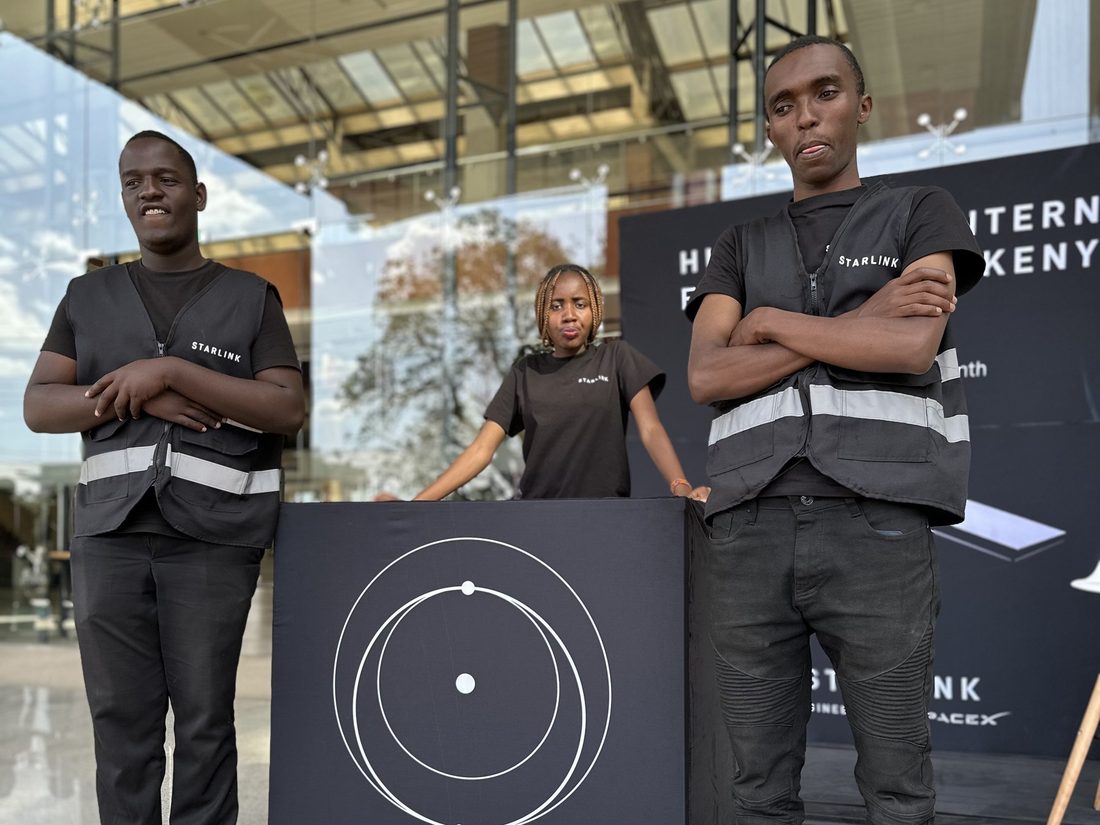 Two brand ambassadors in hi-vis vests standing either side of a Starlink display