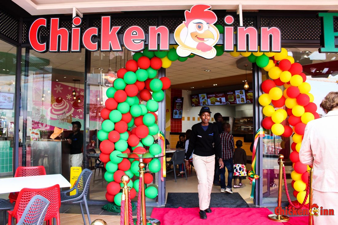 A quick-service restaurant storefront dressed with a balloon arch and hosts at the door