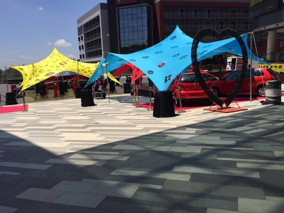 A car display beneath a large heart arch in a shopping plaza