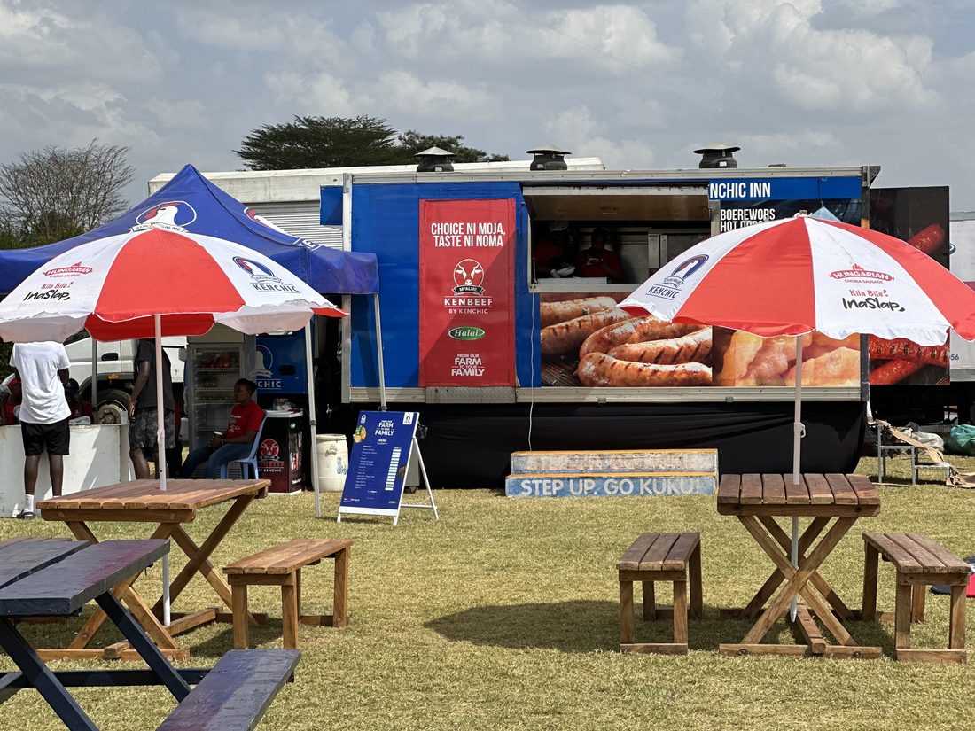 A branded mobile food unit fully rigged, with umbrellas and picnic seating alongside