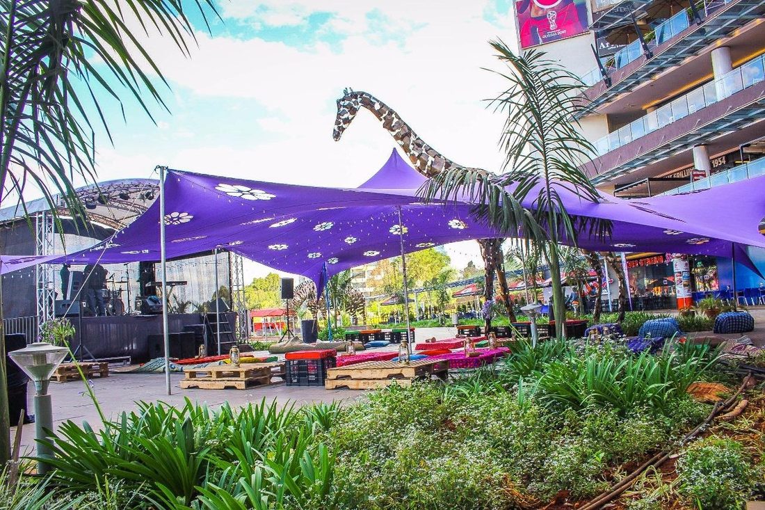A purple stretch-tent build with a giraffe sculpture and a stage