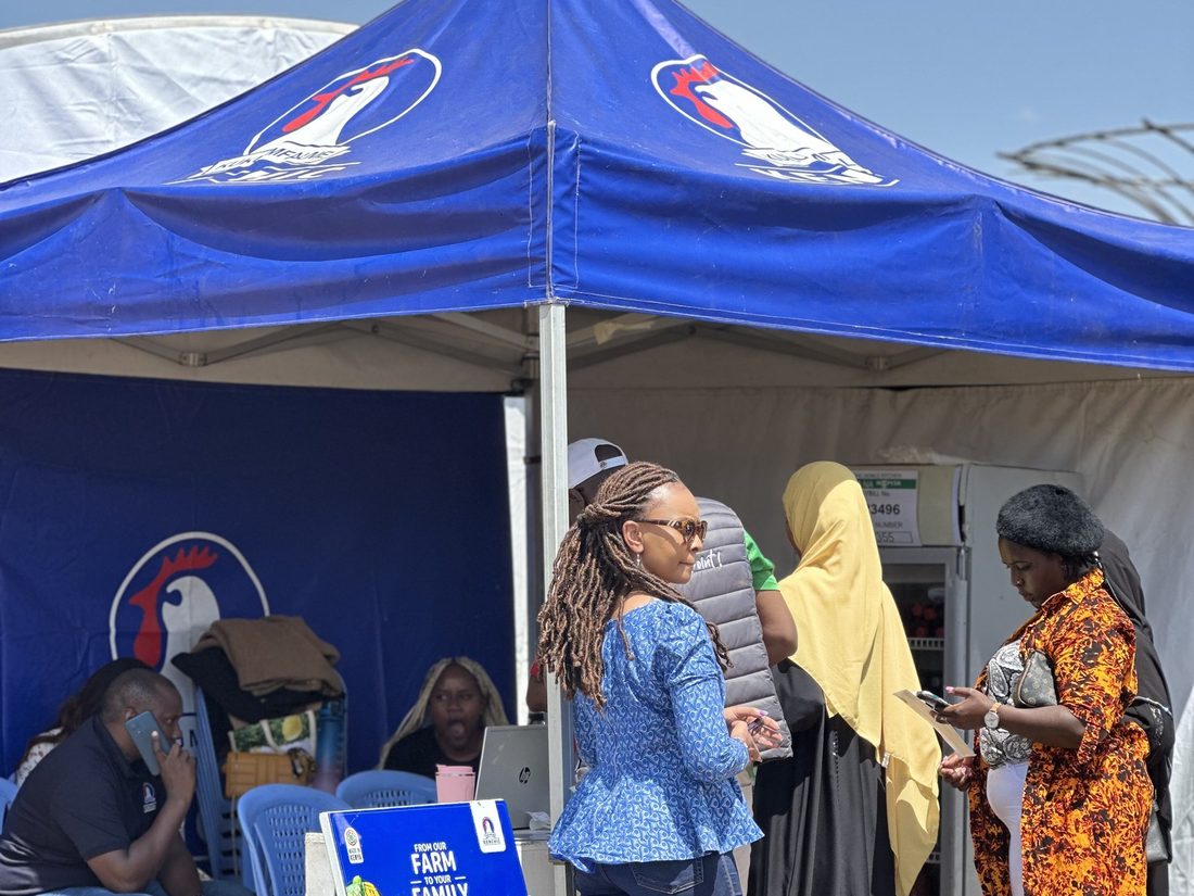 Visitors gathered at a branded gazebo with staff working the counter