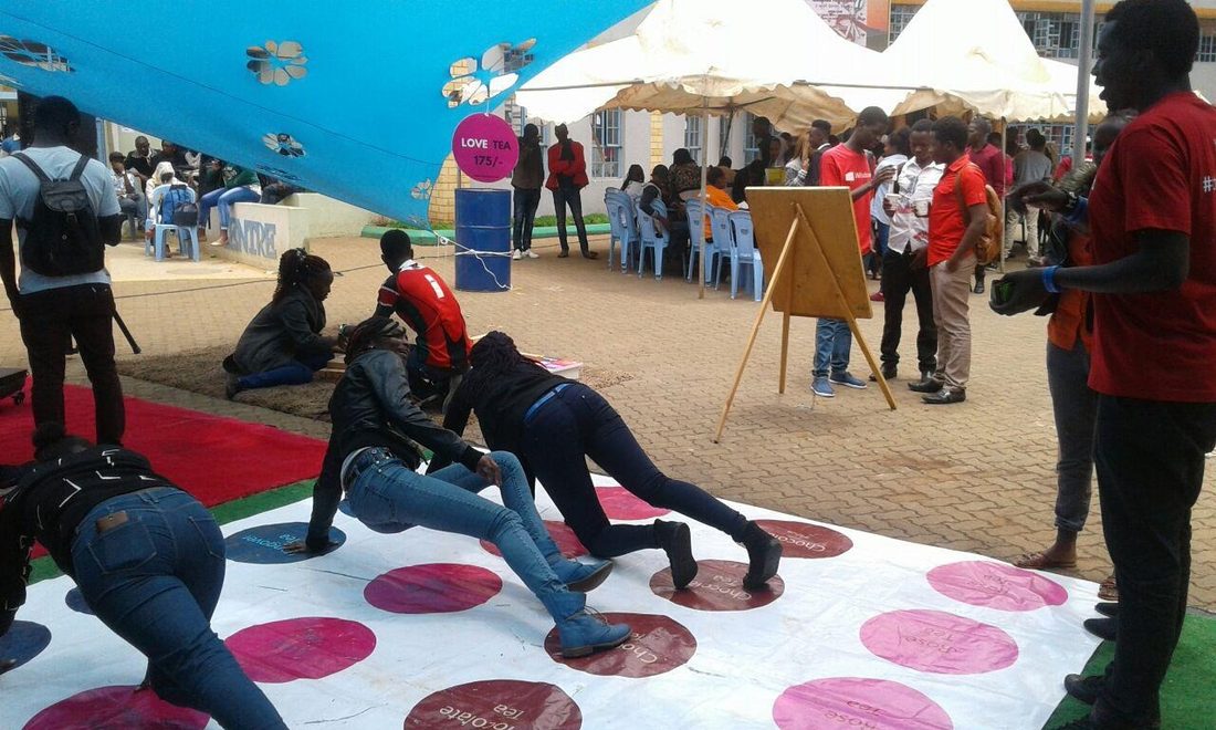 A giant Twister mat set up in front of a student centre with teaching blocks behind