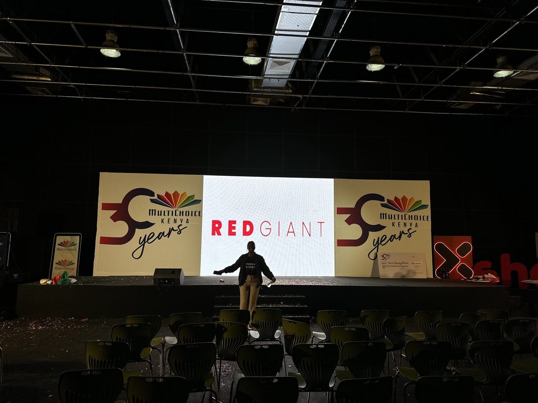 An anniversary stage set with the production company credit shown on the centre screen and a crew member walking the deck