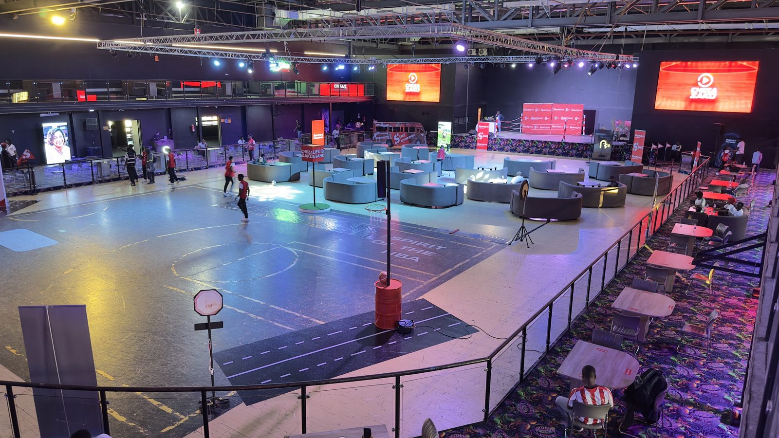 A large arena laid out with banqueting tables facing a stage