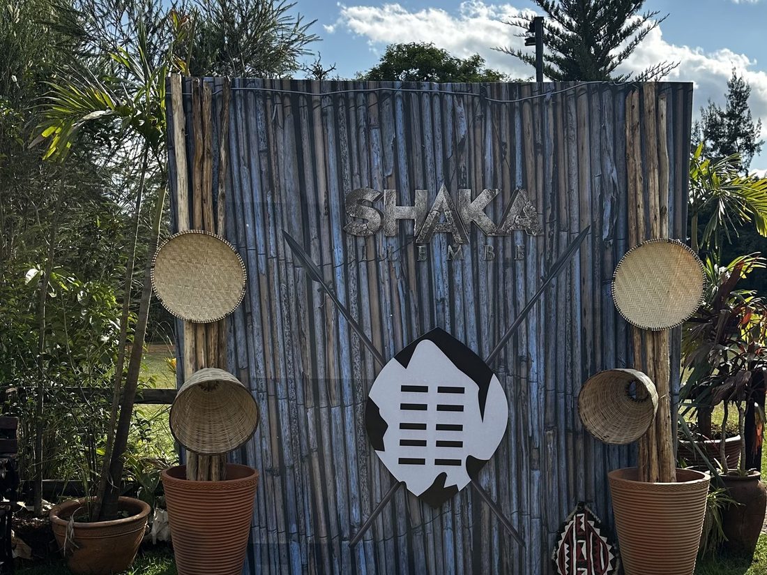 A carved timber backdrop panel set on a cowhide rug in a garden