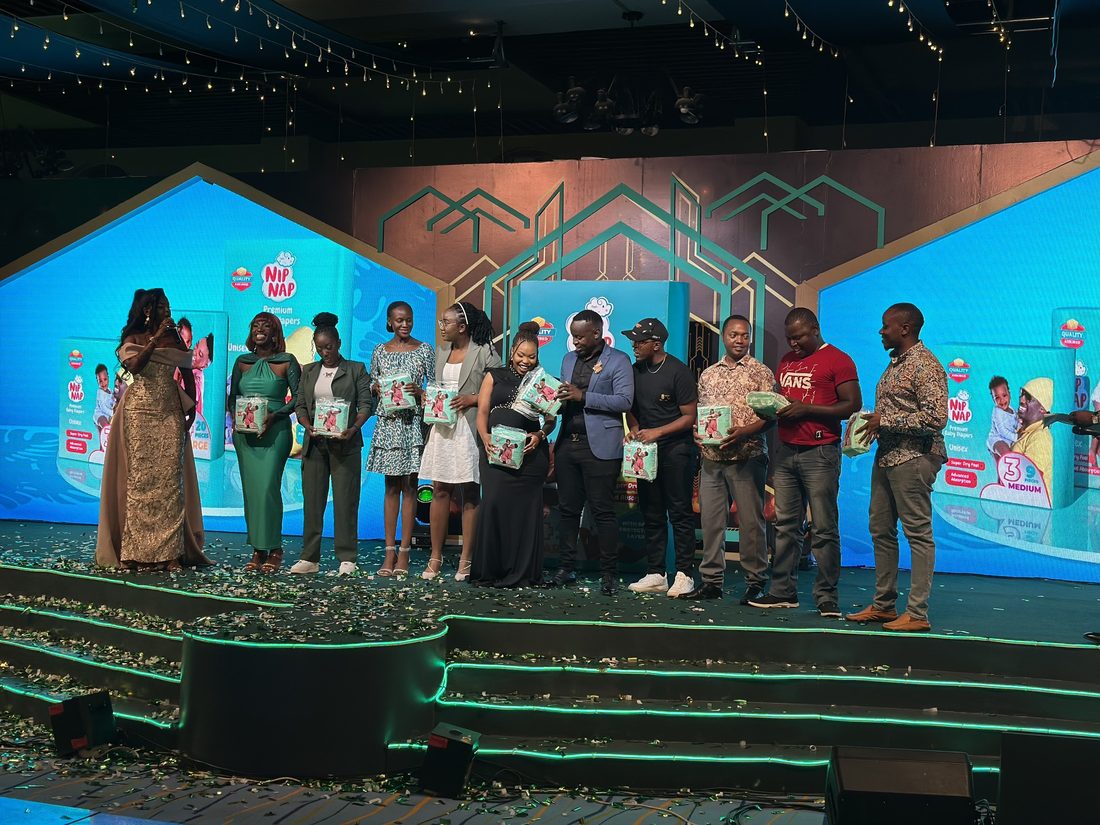 A line of people holding certificates on a lit stage