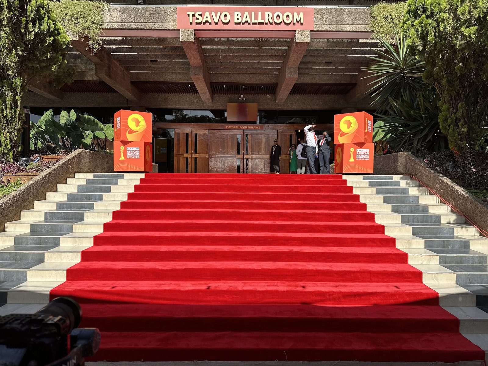 A red carpet running up a broad staircase into a ballroom entrance