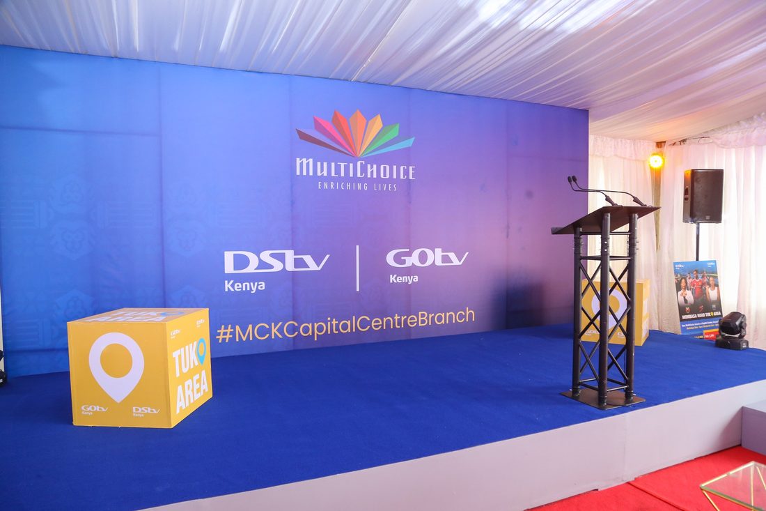 A broadcast-branded stage set with a lectern and a lit backdrop, photographed empty