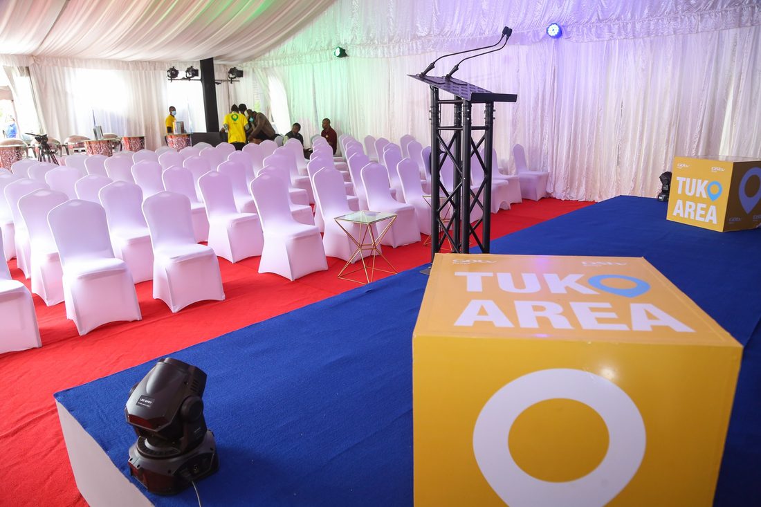 A conference room set and ready before the audience arrives, with a branded stage and plinth