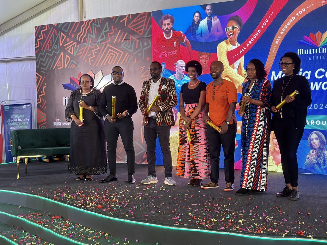 Award recipients standing together on stage in front of an LED wall