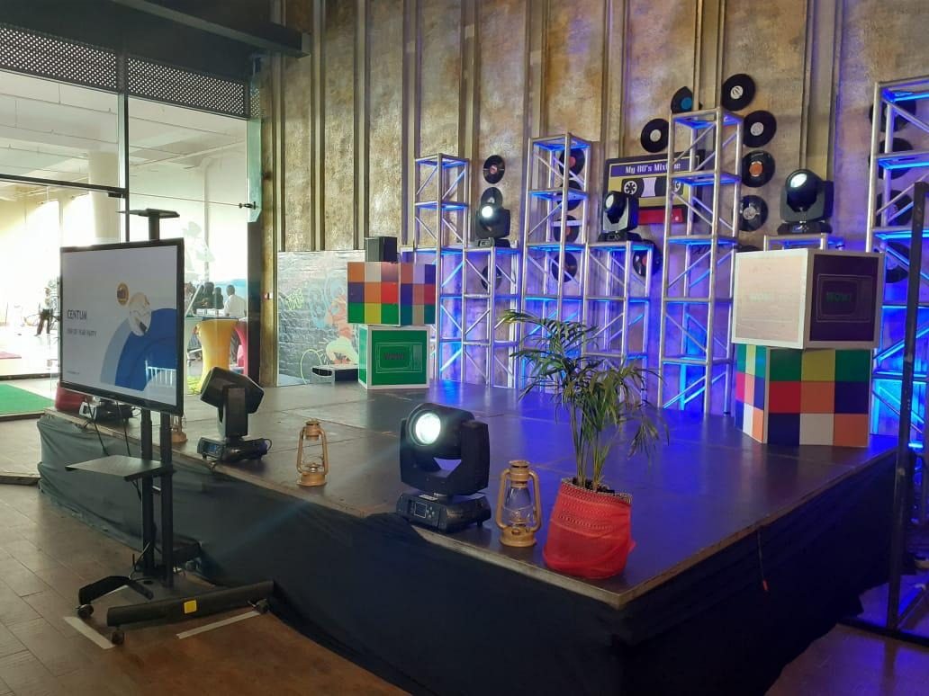 An end-of-year party stage with a vinyl-record truss wall and a cassette prop