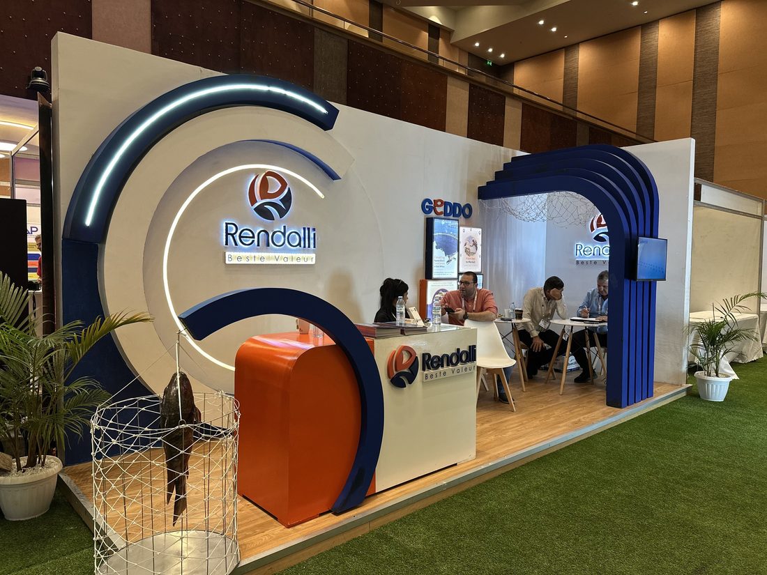 A curved blue and orange exhibition stand with a reception counter