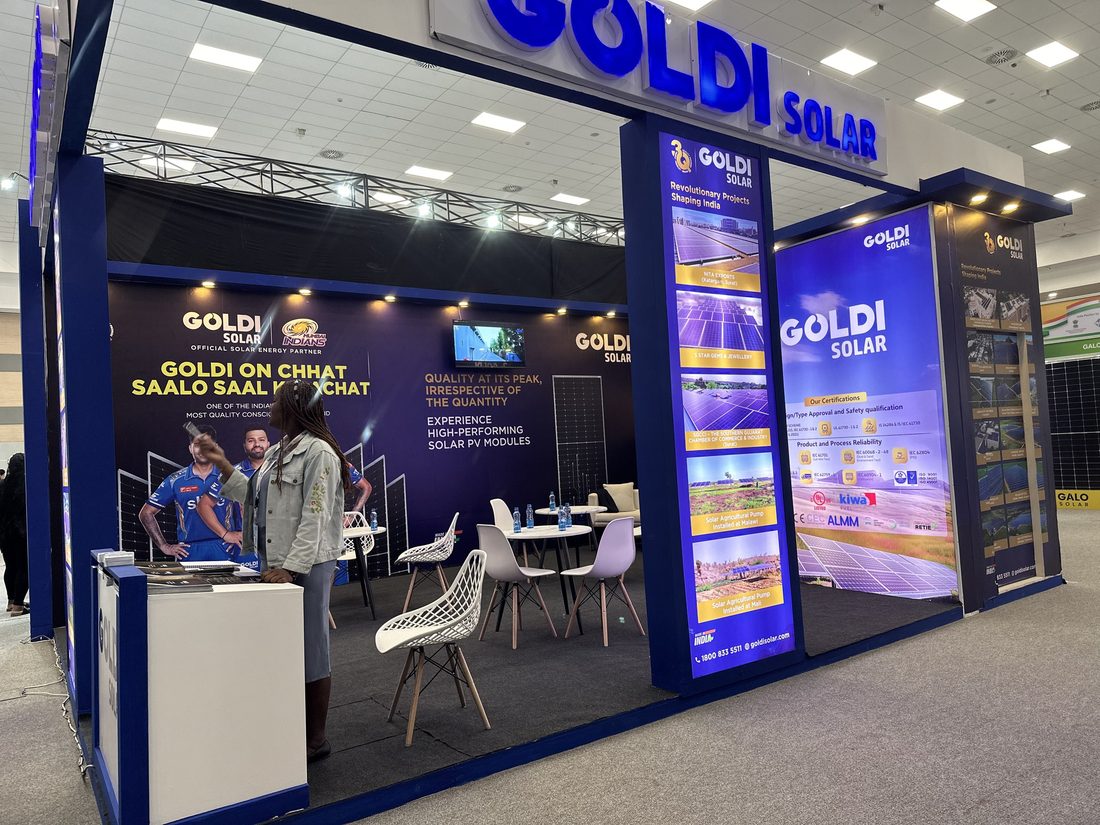 A wide view of a Goldi Solar stand with seating and staff at the desk