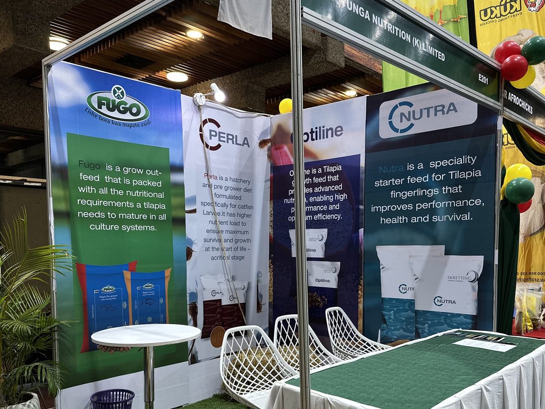 An exhibition stand with printed product panels, a bistro table and seating