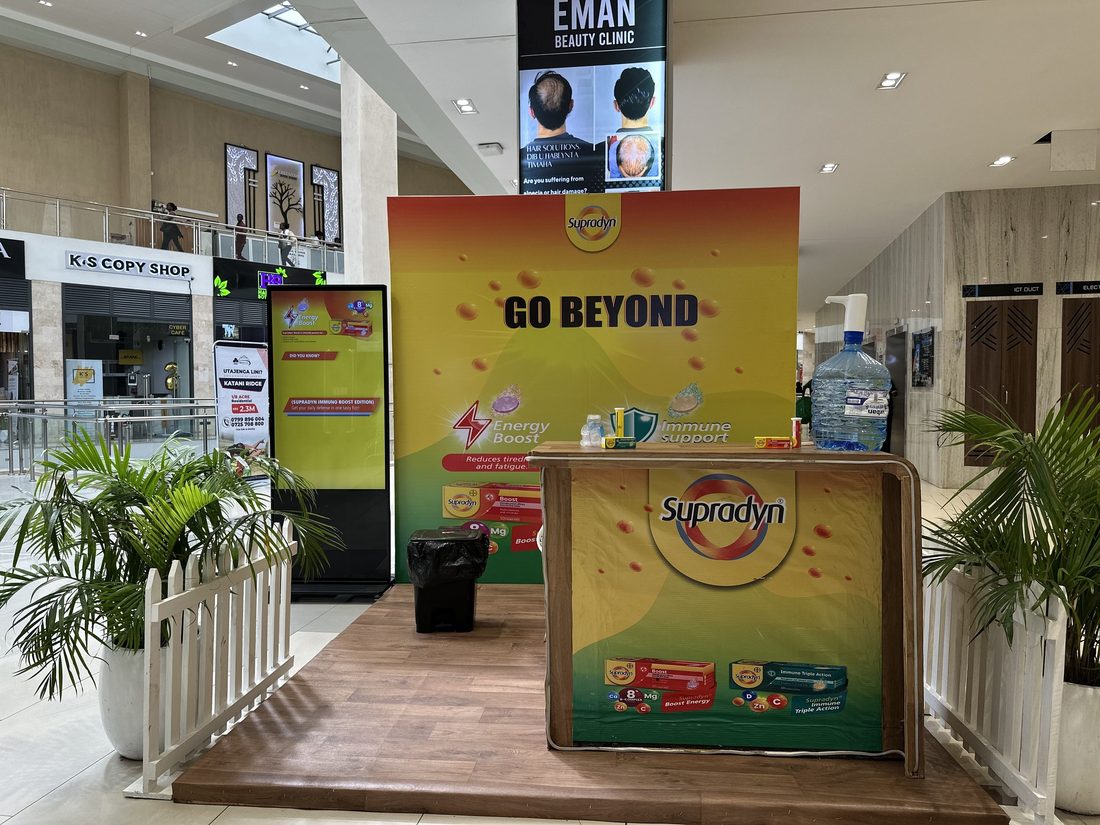 A Supradyn stand with a printed product wall and planting