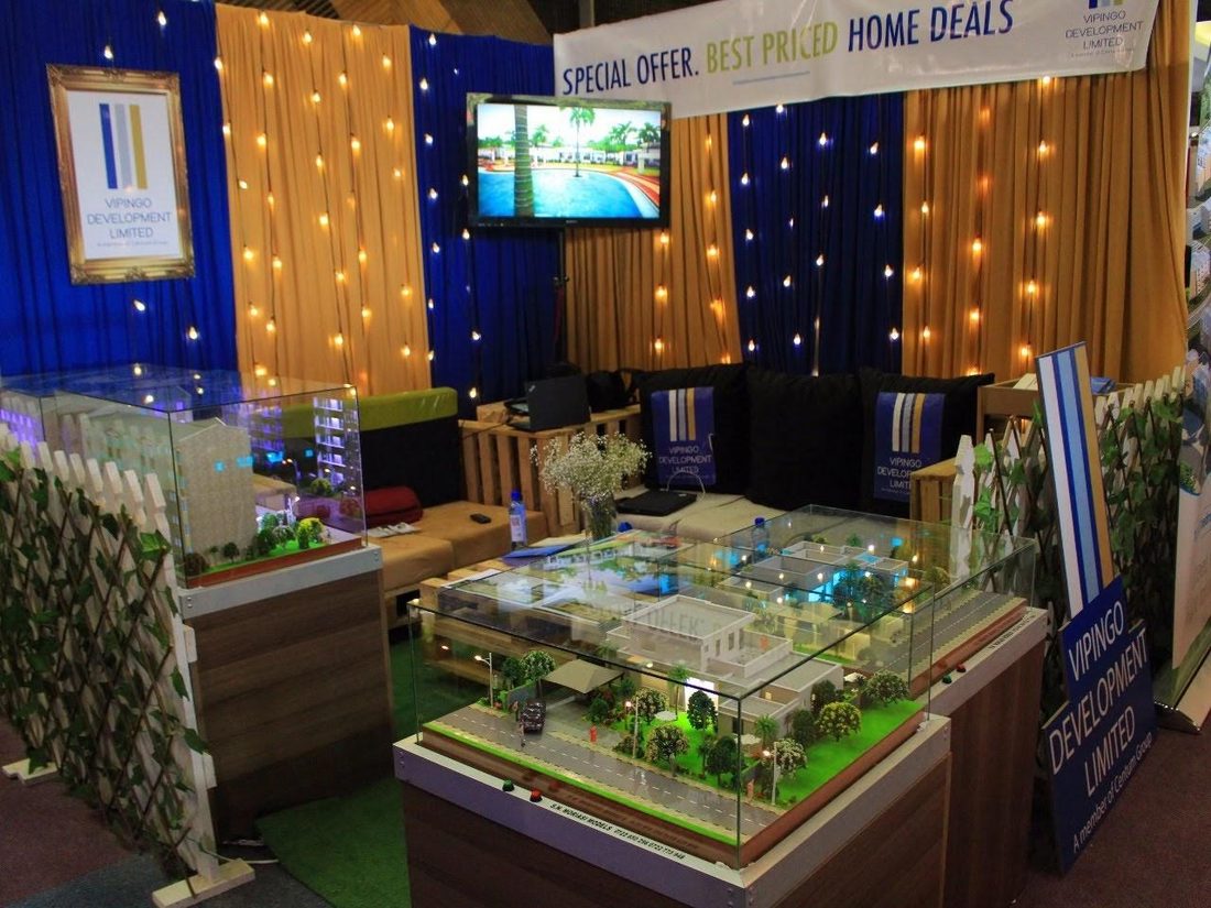 A property stand with lit architectural models under glass
