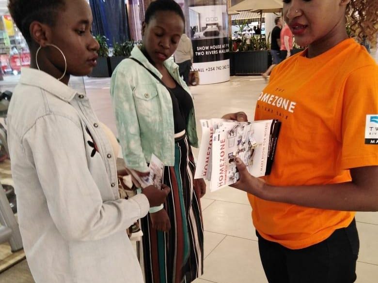An ambassador briefing two shoppers