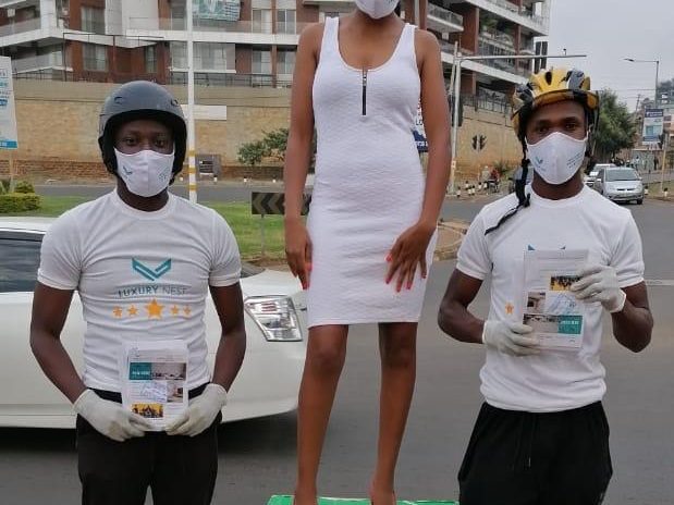 A street team with a host standing on a plinth flanked by two distributors handing out samples