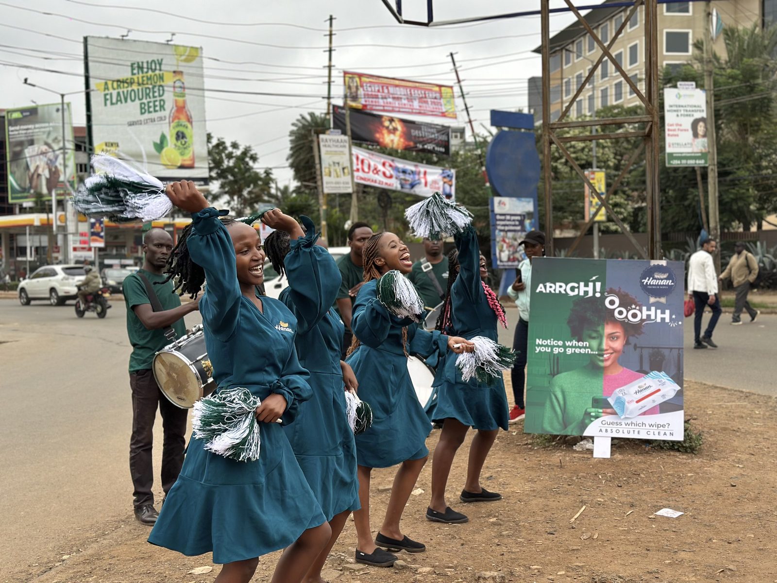 A street team in matching uniforms performing with printed placards at a roadside