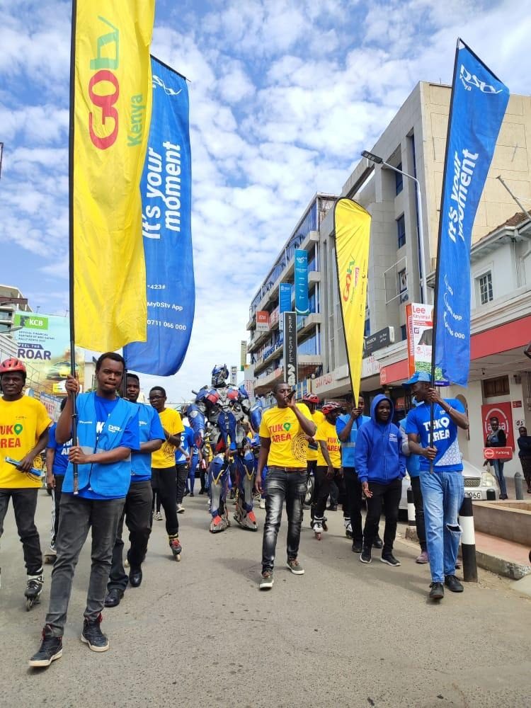 A street team walking a route behind a branded flag