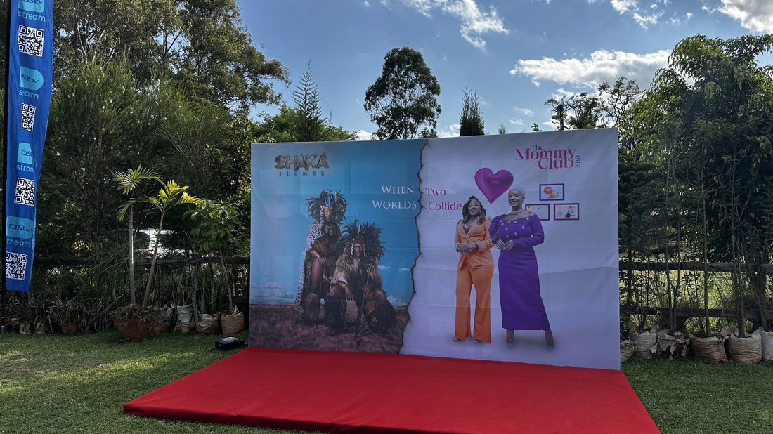 A printed launch backdrop and red carpet set up on a lawn