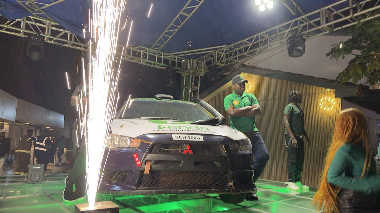 A vehicle reveal under stage lighting with pyrotechnic fountains firing on either side of it