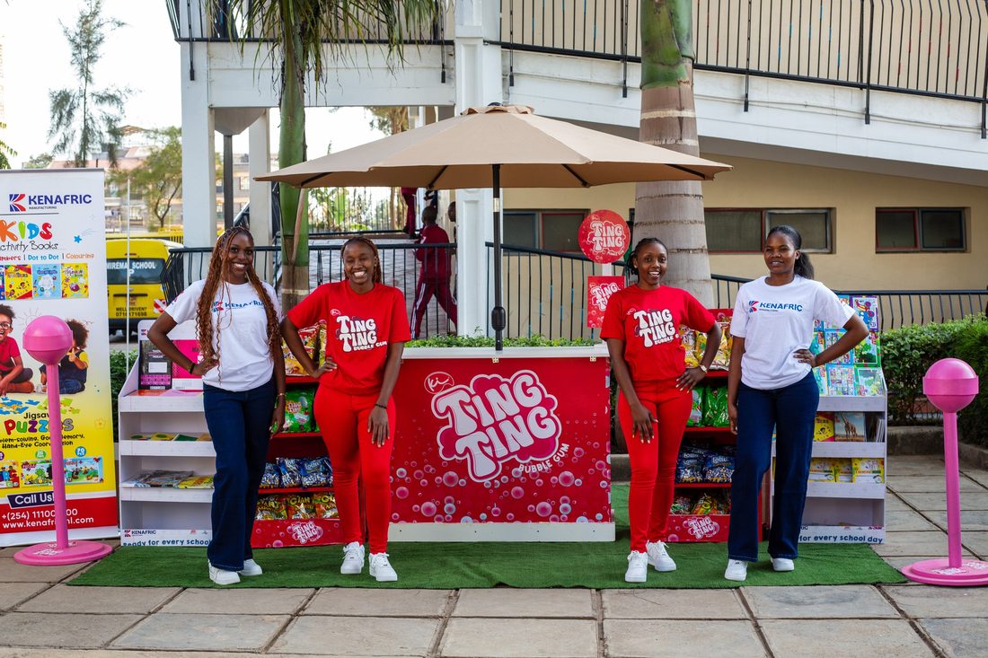 Three brand ambassadors in matching kit standing at a stocked outdoor product stand