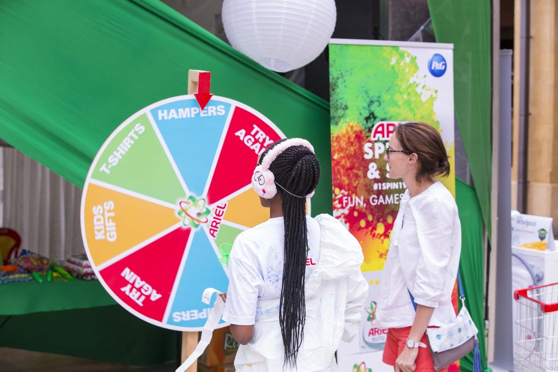A participant spinning a branded prize wheel at an Ariel activation