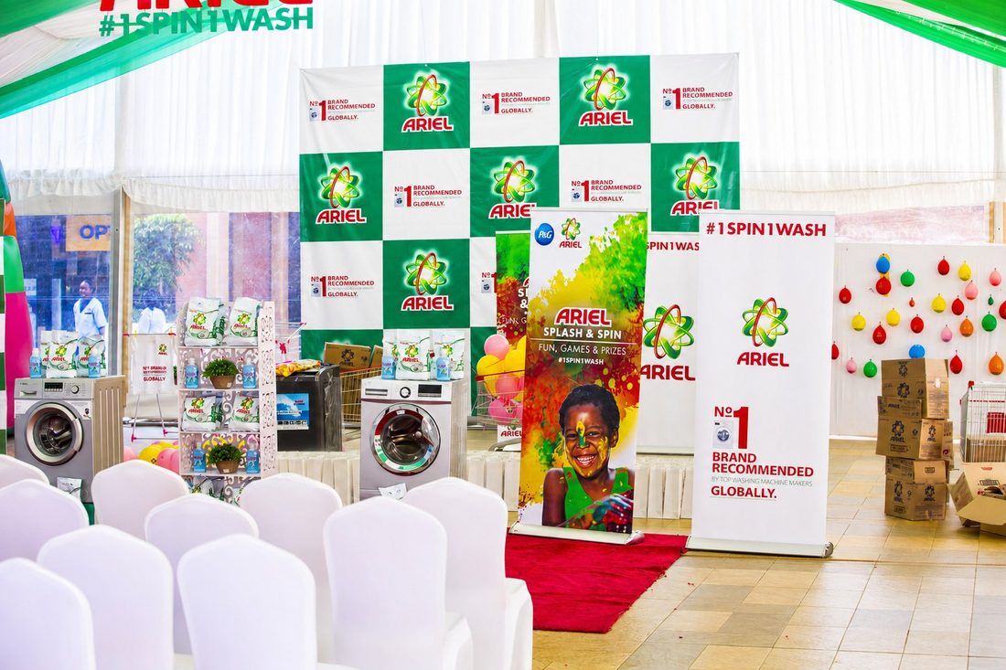 An Ariel #1SPIN1WASH marquee with live washing machines, a branded chequerboard wall and a balloon game