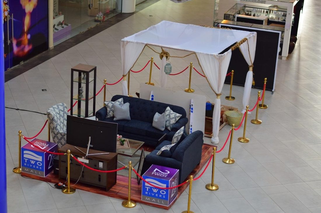 A dressed lounge set inside a gold rope at a shopping-centre activation