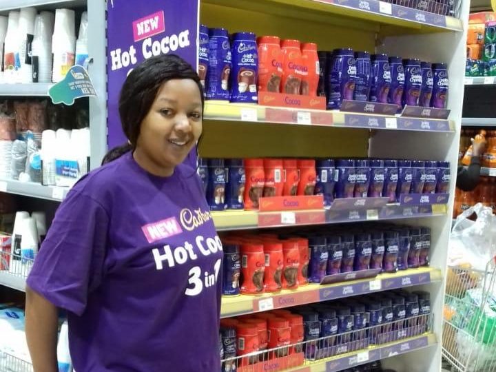 A promoter in front of a hot cocoa shelf display in store