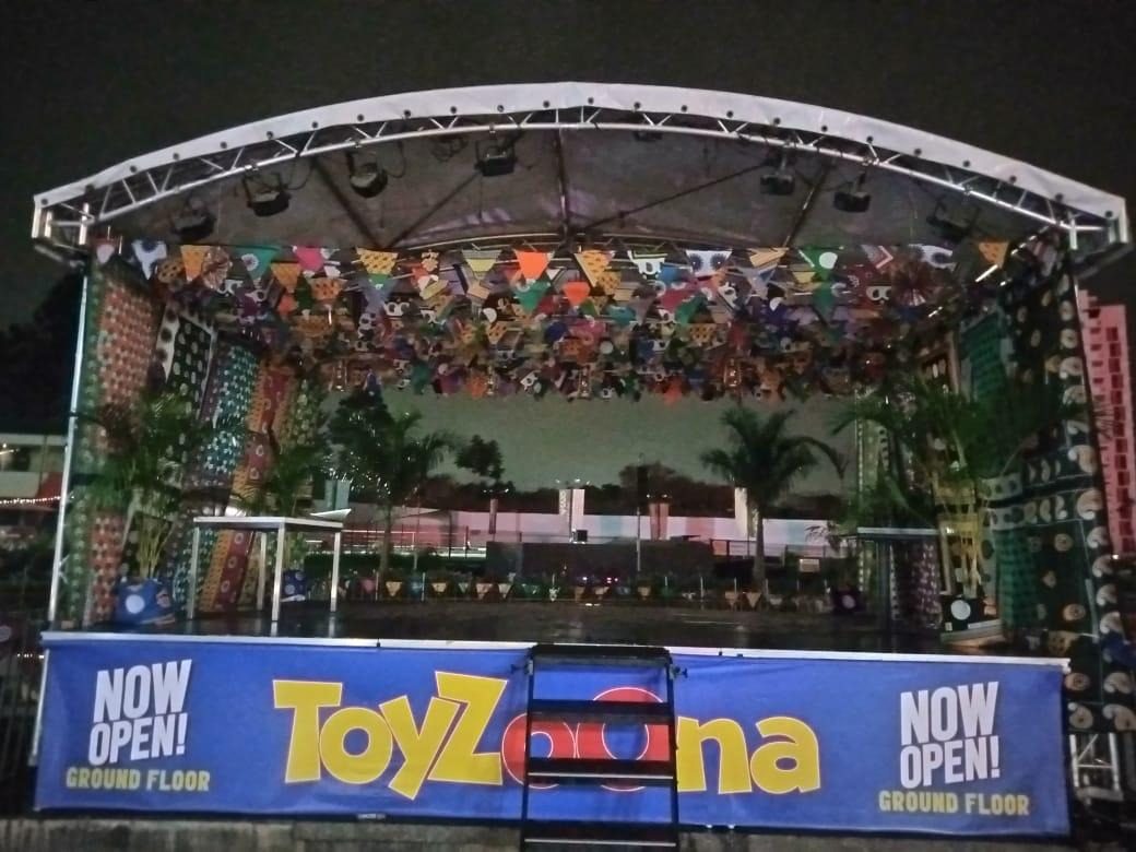 A dressed stage in a shopping centre announcing a store opening