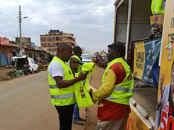 A hi-vis crew working the side of the truck at a stop