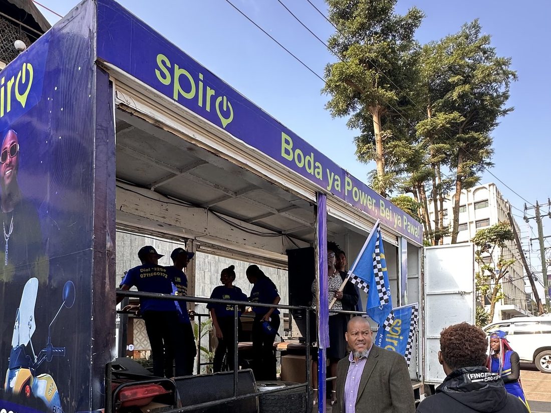 A Spiro truck with the side dropped to form a stage, electric motorcycles displayed inside the bay