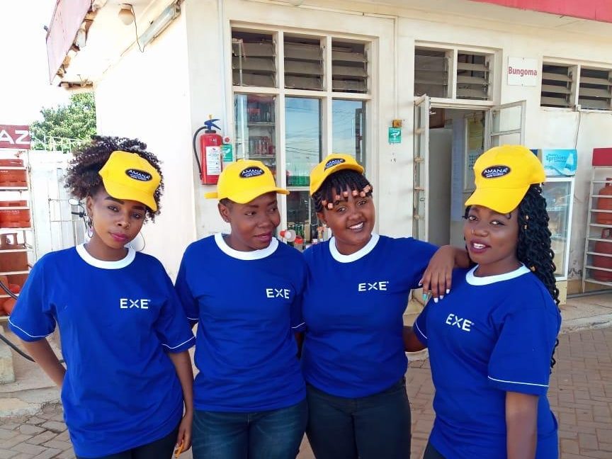 Four brand ambassadors outside a fuel-station shop