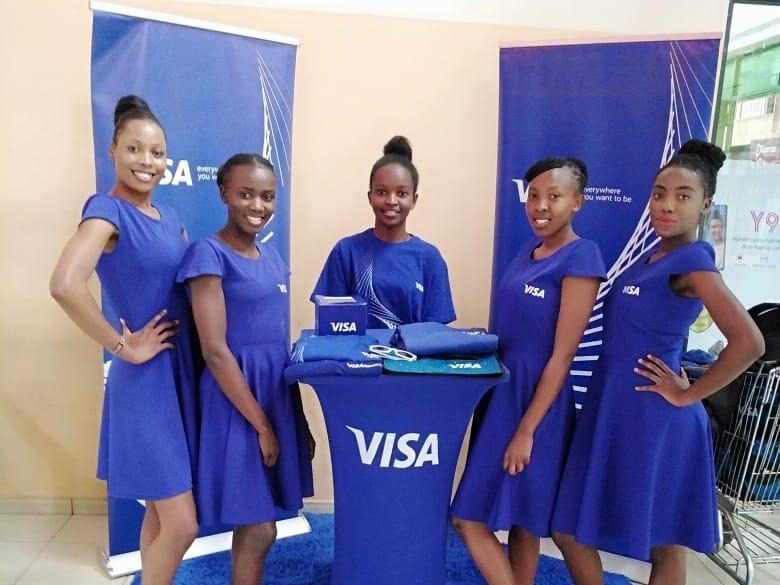 Five VISA brand ambassadors standing between two branded backdrops