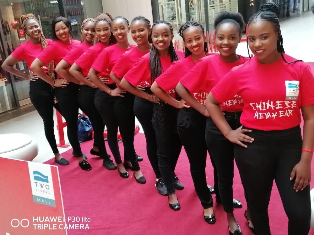 A host team of nine lined up on a red carpet