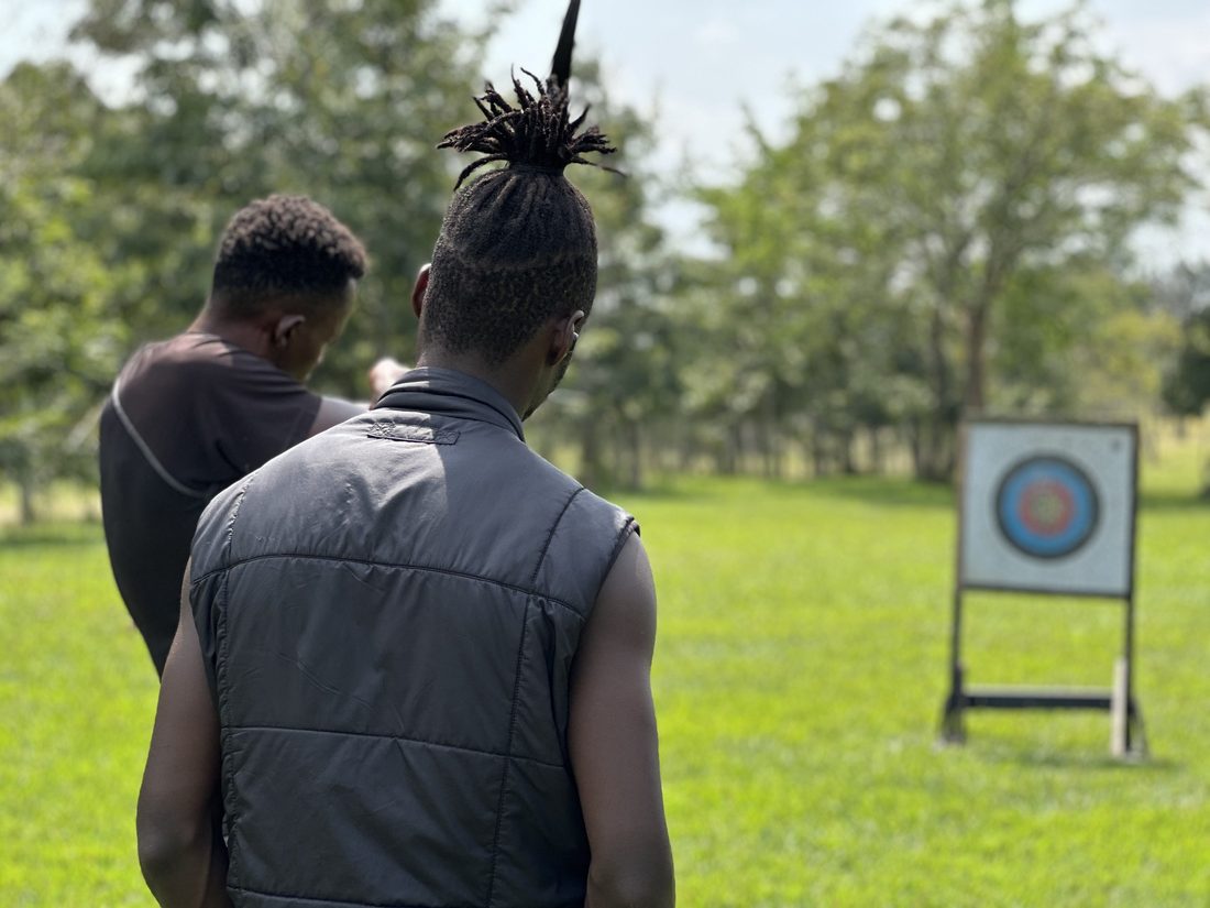 Two people at an archery target set up on a lawn