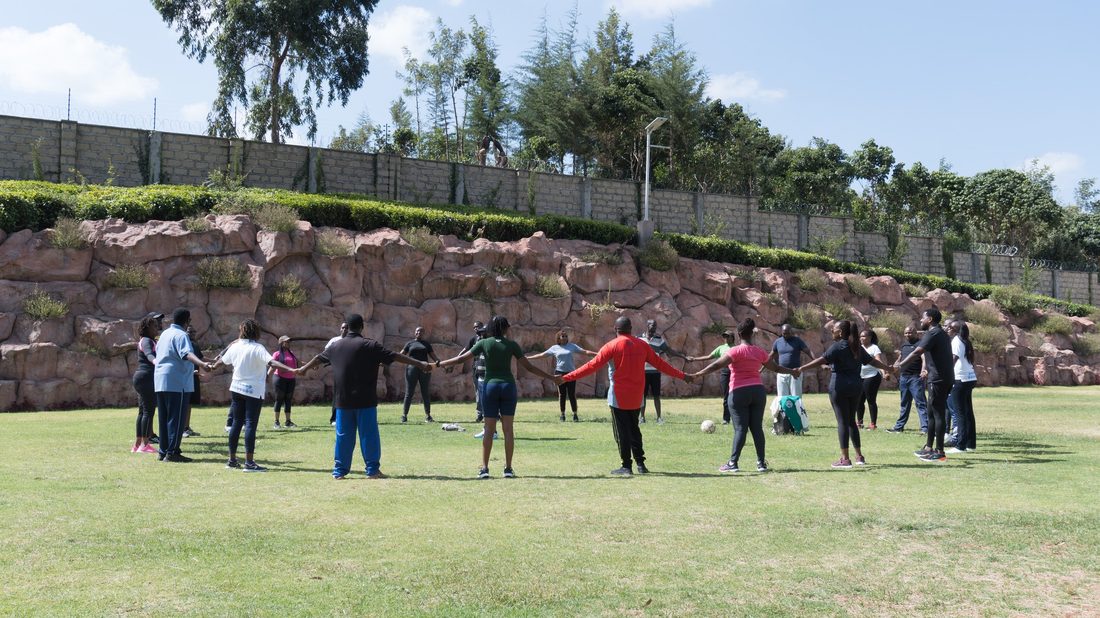 A group spread across a lawn taking part in an outdoor activity
