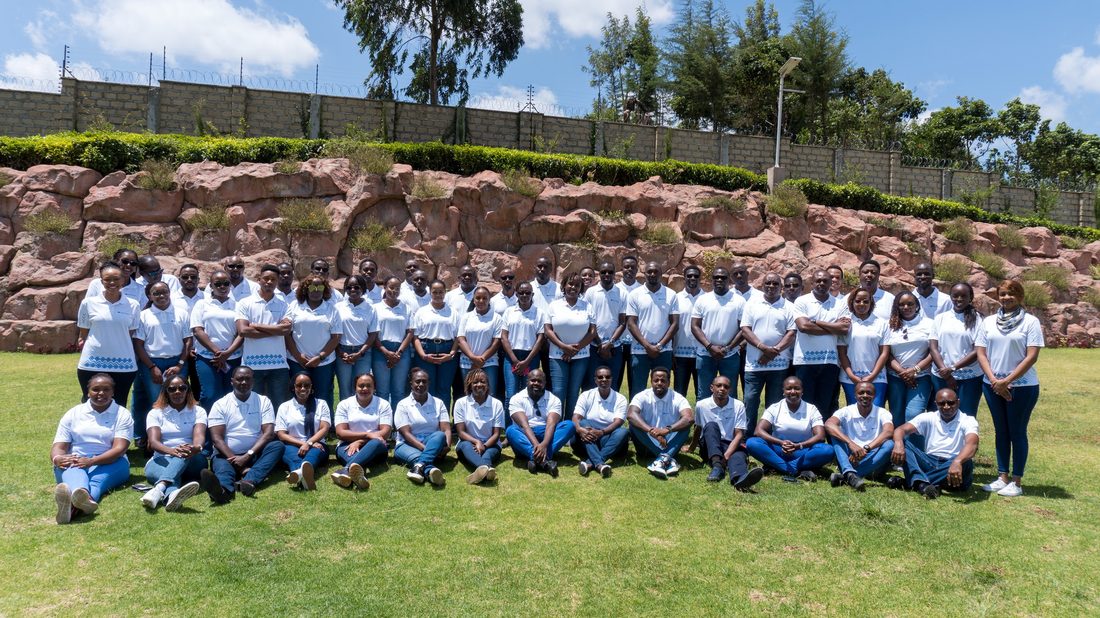 A large delegation photographed together in matched team tee shirts