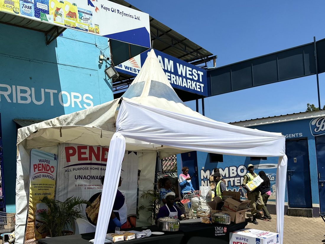 A distributor stand with stacked product cases outside a supermarket