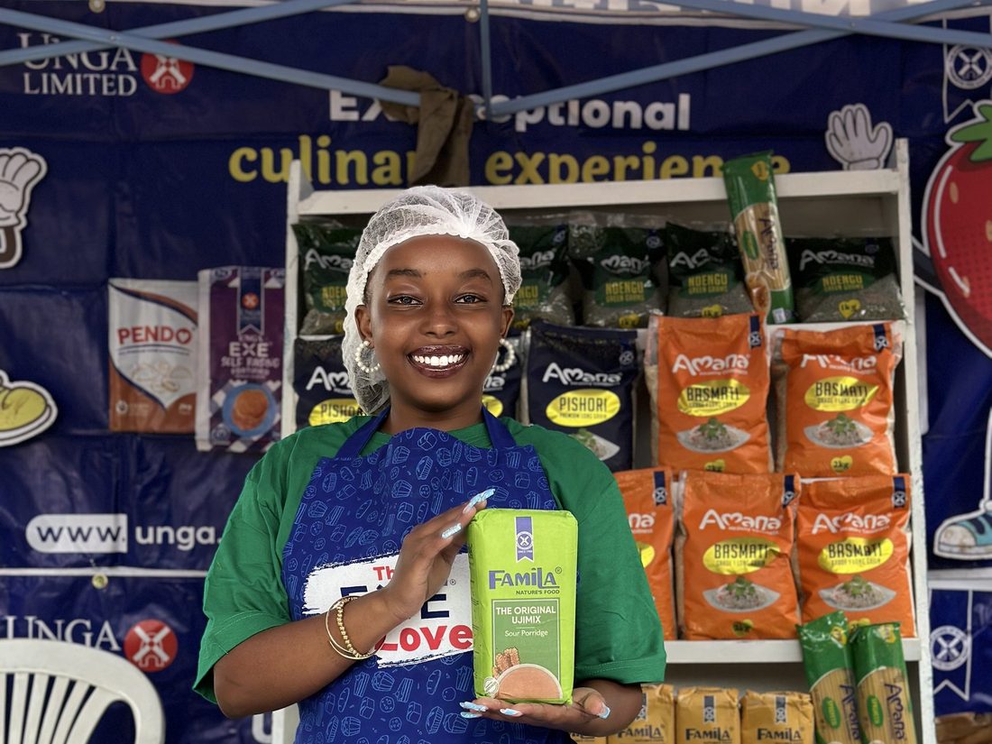 A hostess in branded uniform beside a fully stocked product stand
