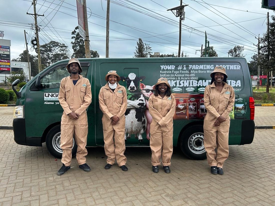 Five representatives in Unga farm overalls in front of a branded route van