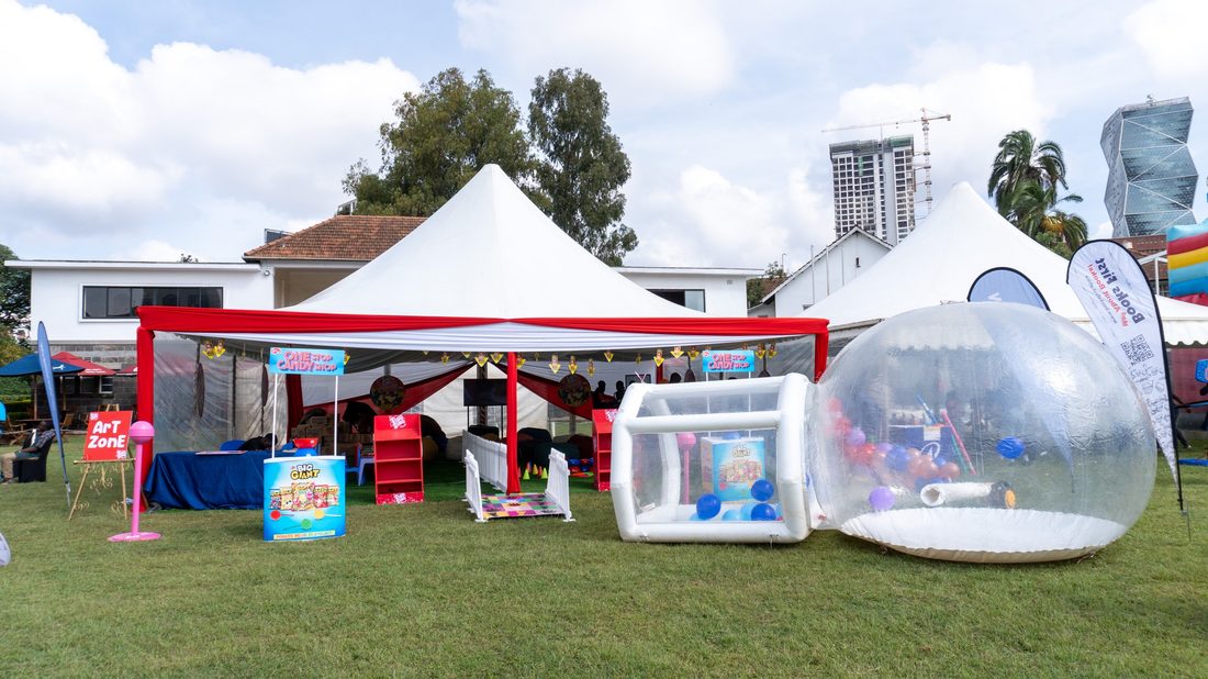 Inflatable transparent domes and branded gazebos set out across a fairground